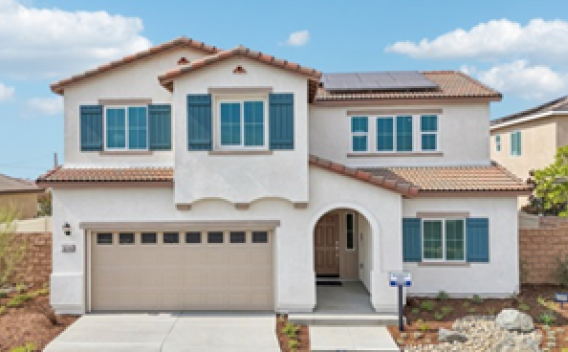 Spacious two-story house with white stucco walls, blue shutters, and a red-tiled roof. Features a two-car garage and manicured, rock-adorned front yard.