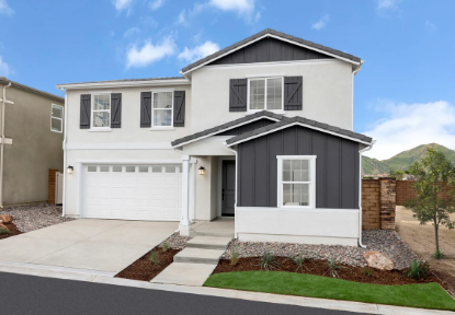A modern two-story house with a white facade and dark gray accents, featuring a porch and a garage, surrounded by landscaped gravel and grass.